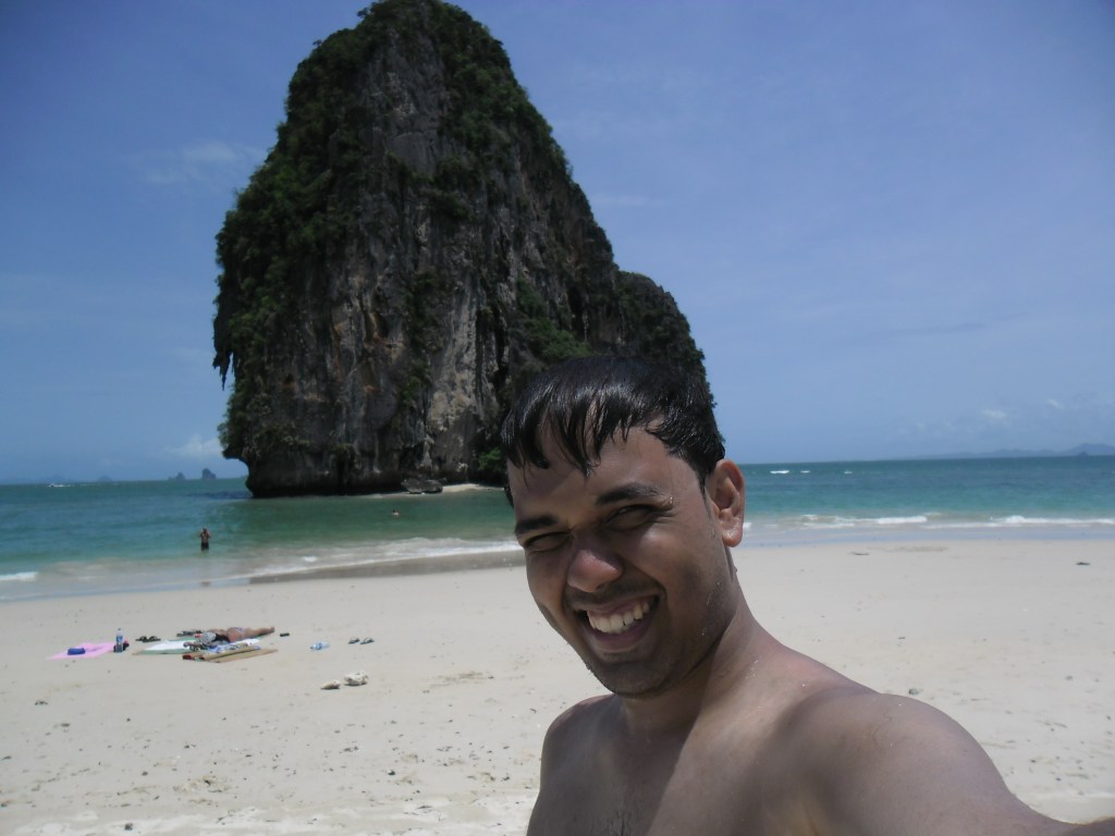 Traveller on a beach beside a limestone cliff